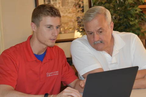 Preston and a man looking at a laptop together.