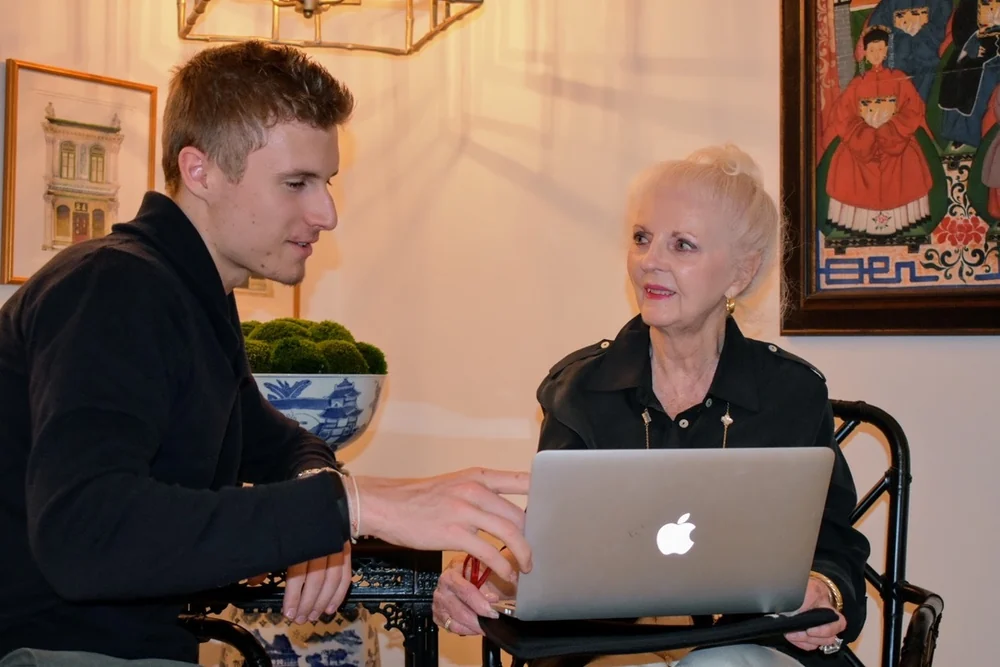 Preston and a woman reviewing an open Apple laptop
